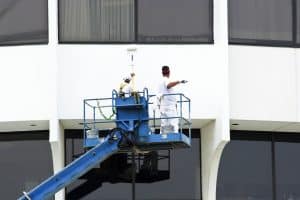 two men painting a building's wall
